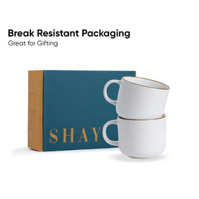 Two white mugs stacked on top of each other with a blue box labeled 'SHAY' in the background.