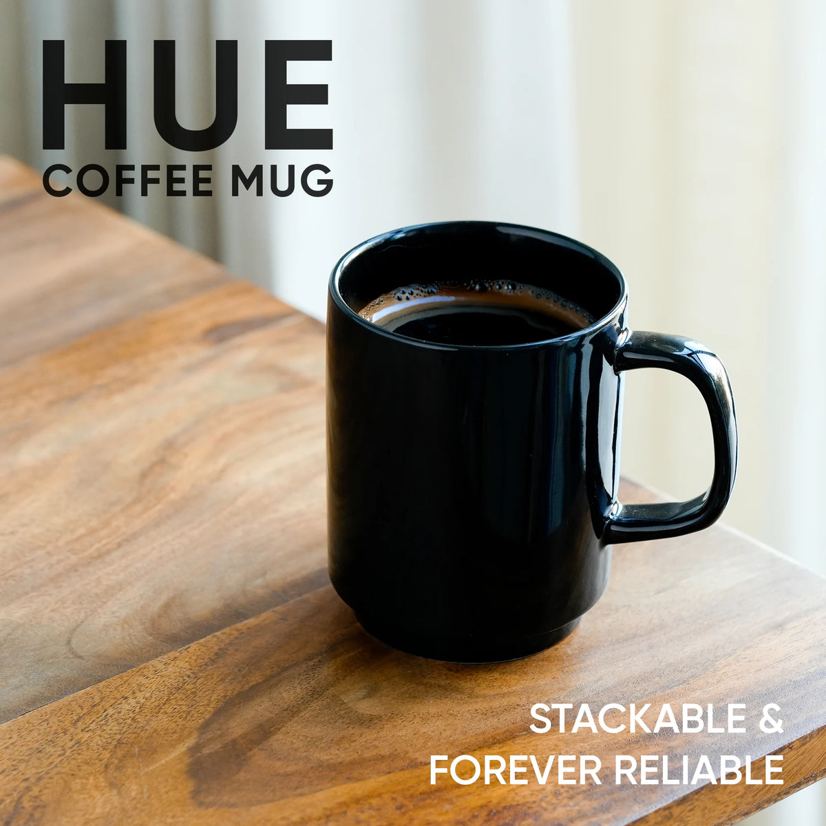 Black coffee mug on a wooden surface with 'HUE' branding and text.