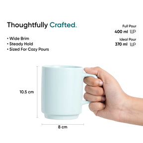 White mug held by a hand with measurements and text on a white background