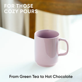 Pink mug on a white surface with text about cozy pours and drink options.