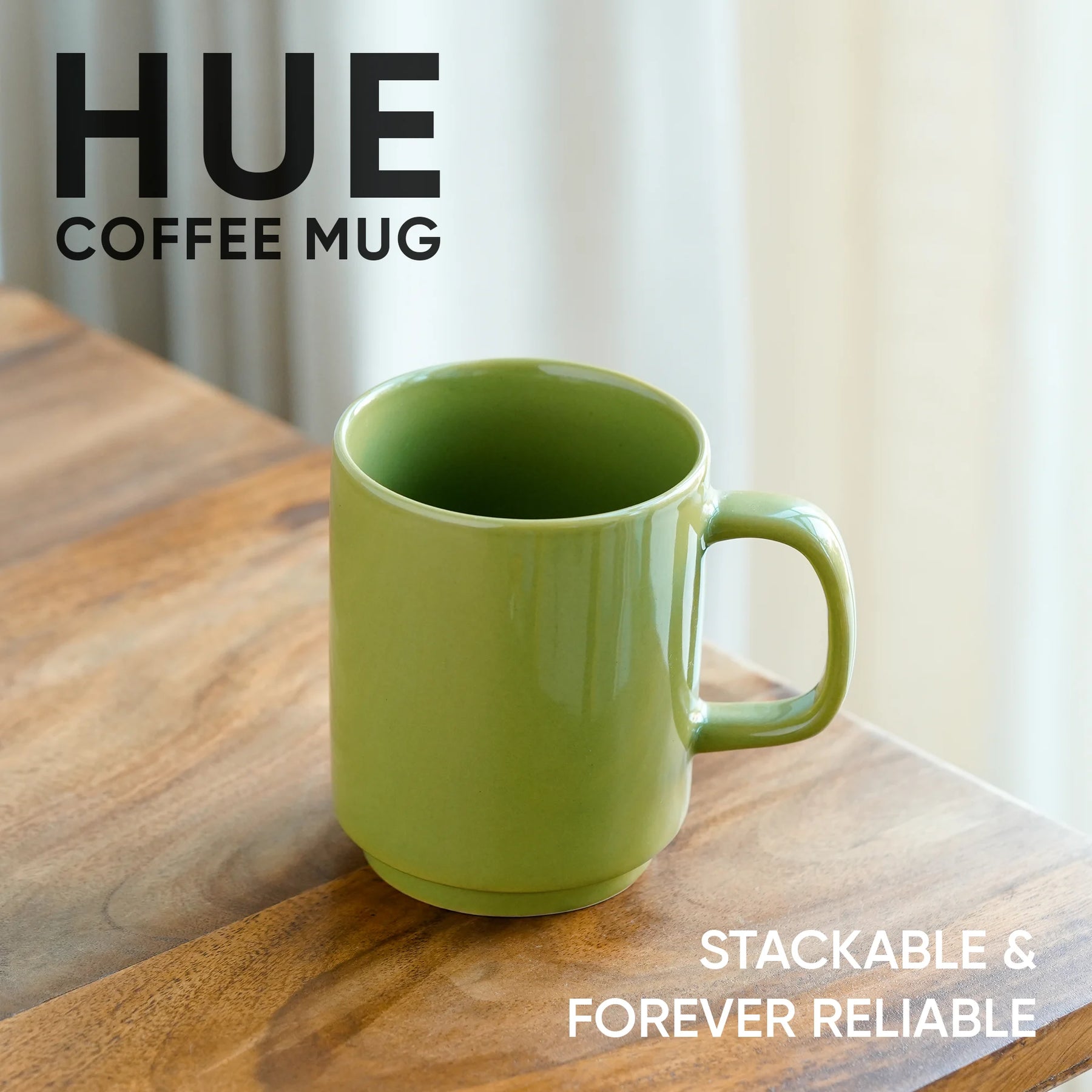 Green coffee mug on a wooden surface with 'HUE' branding and text.
