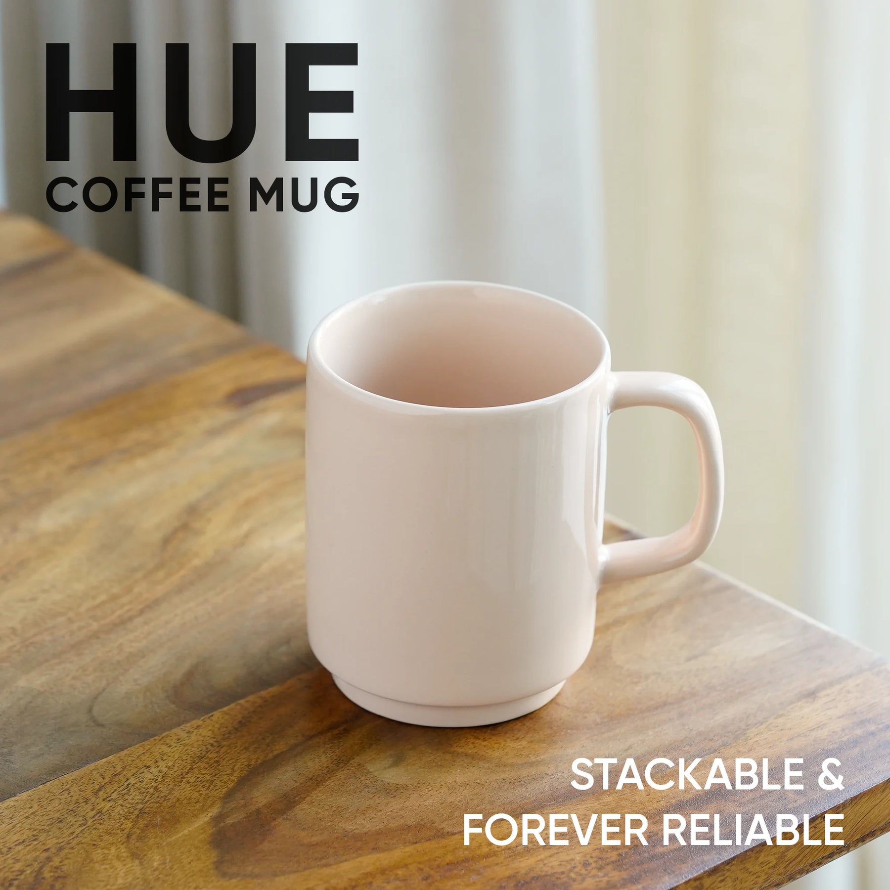 White coffee mug on a wooden surface with 'HUE' branding and text about stackability and reliability.