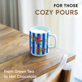 Mug with floral design on a wooden surface, text 'For those cozy pours' and 'From Green Tea to Hot Chocolate'.