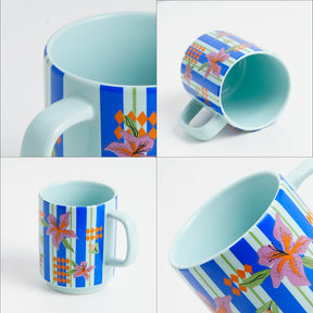 Colorful mug with floral and striped design on a white background