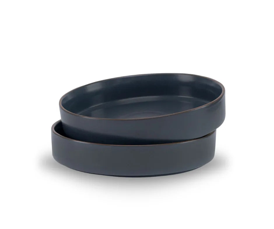 Two dark blue ceramic bowls stacked on a white background