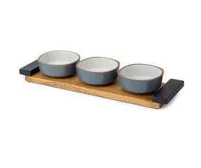 Set of three gray bowls on a wooden tray with black ends against a white background