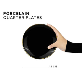 Hand holding a black porcelain quarter plate with gold rim on a white background