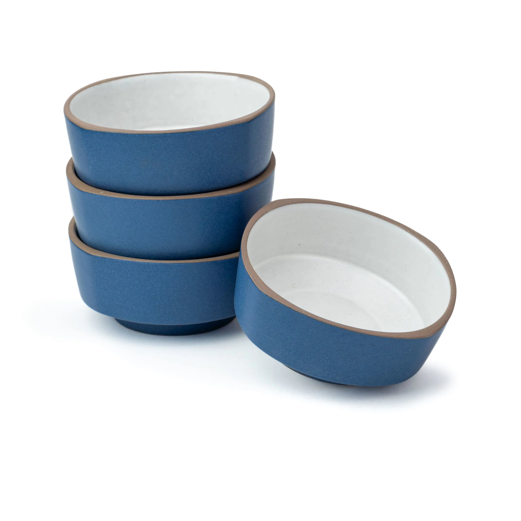 Set of blue ceramic bowls with white interiors on a white background