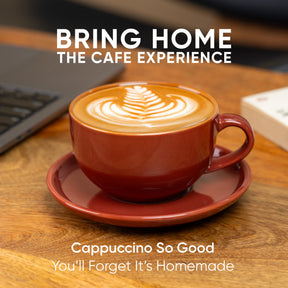 Red cup of cappuccino on a wooden table with text 'Bring Home the Cafe Experience'.