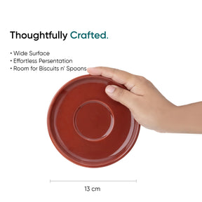 Red ceramic plate held by a hand with product features listed above on a white background