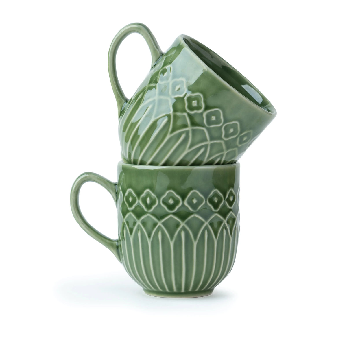 Two green ceramic mugs with decorative patterns stacked on a white background