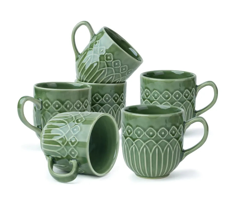 Set of green ceramic mugs with geometric patterns on a white background