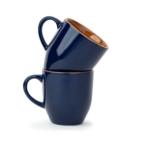 Two navy blue mugs with copper interior on a white background