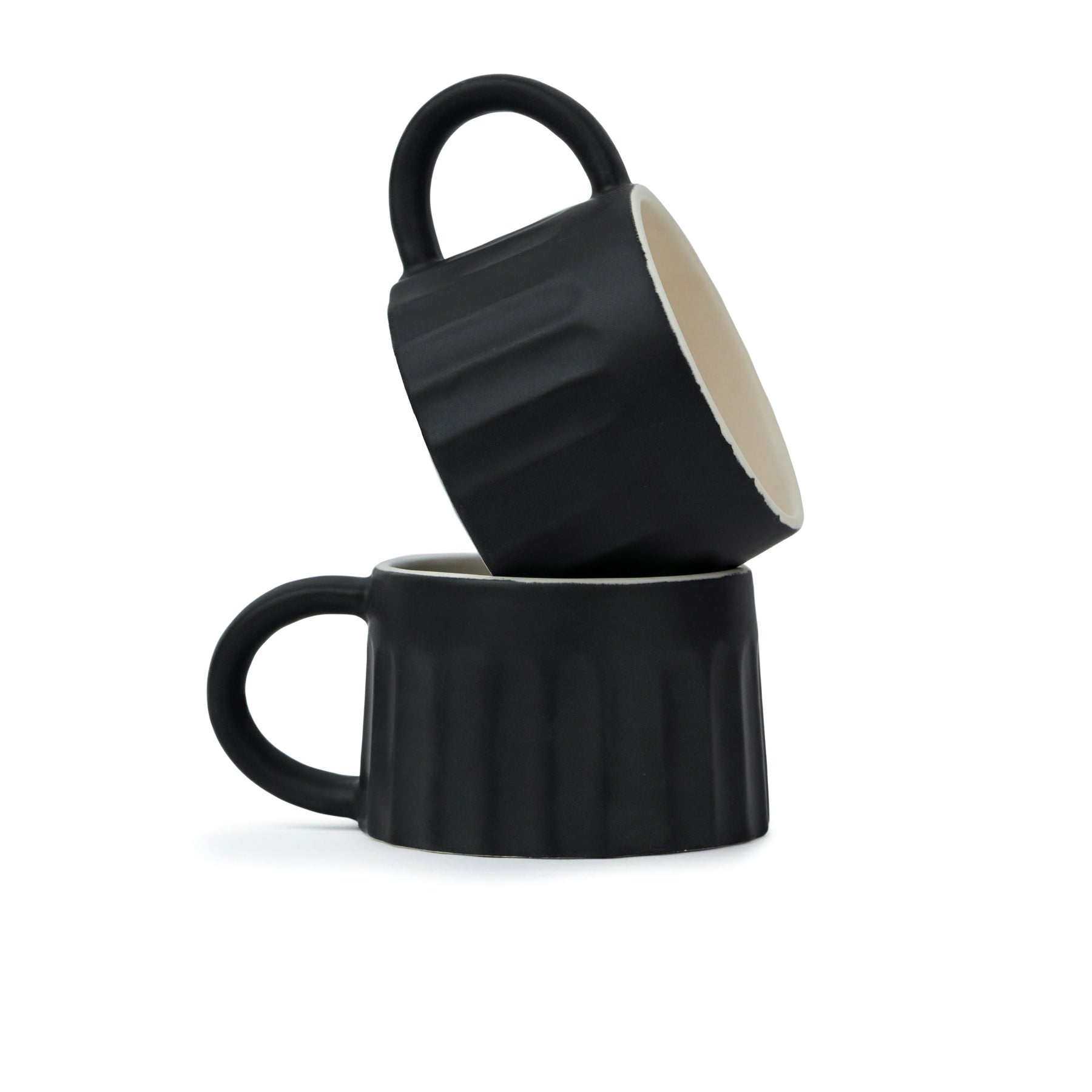 Two black mugs stacked on a white background