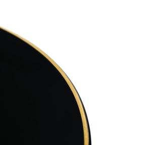 Black circular object with a gold rim on a white background