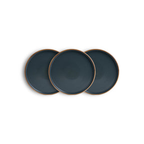 Three dark blue plates with bronze rims on a white background