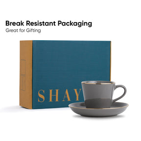 Gray mug and saucer set with 'SHAY' branding on a blue box, labeled 'Break Resistant Packaging'.