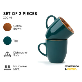 Set of two teal mugs with coffee brown interior, labeled 'Handmade & Human'.
