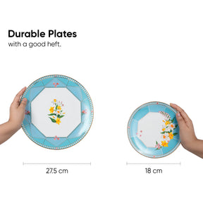 Two hands holding decorative plates with floral designs, showing size comparison.