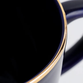 Close-up of a blue ceramic bowl with a gold rim on a white background