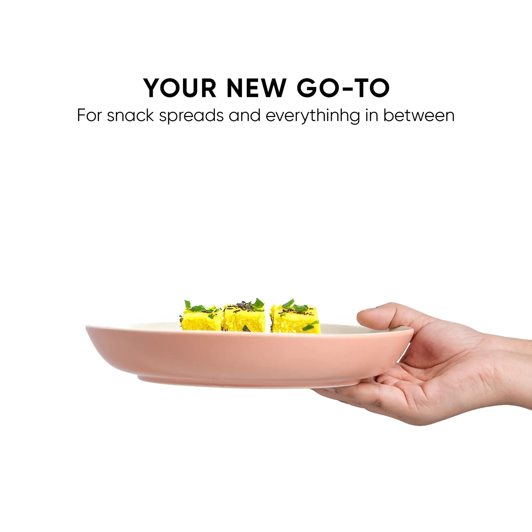 Hand holding a pink plate with snack spread on a white background