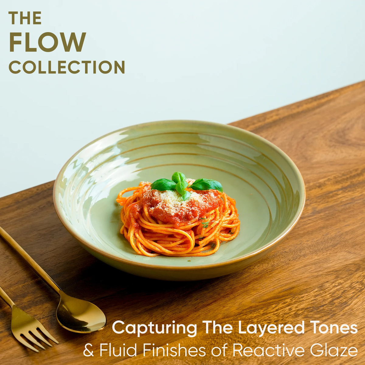 Green bowl with spaghetti on a wooden table, featuring 'The Flow Collection' text.