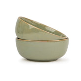 Two green ceramic bowls stacked on a white background