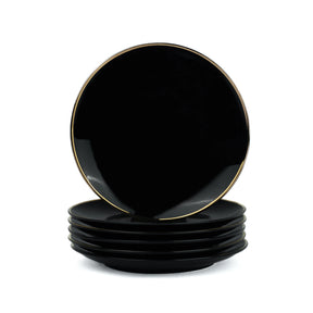 Set of black plates with gold rims on a white background