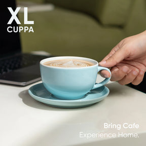 Hand holding a blue mug of coffee with 'XL Cuppa' branding and text 'Bring Cafe Experience Home'.