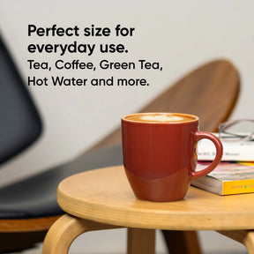 Red mug with a drink on a wooden table, text about tea and coffee.