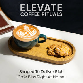 Cup of coffee with latte art on a wooden tray with a cookie, against a dark background.