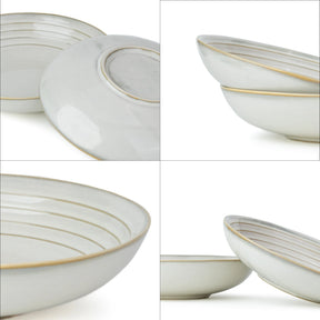 Set of white ceramic bowls with gold rims on a white background