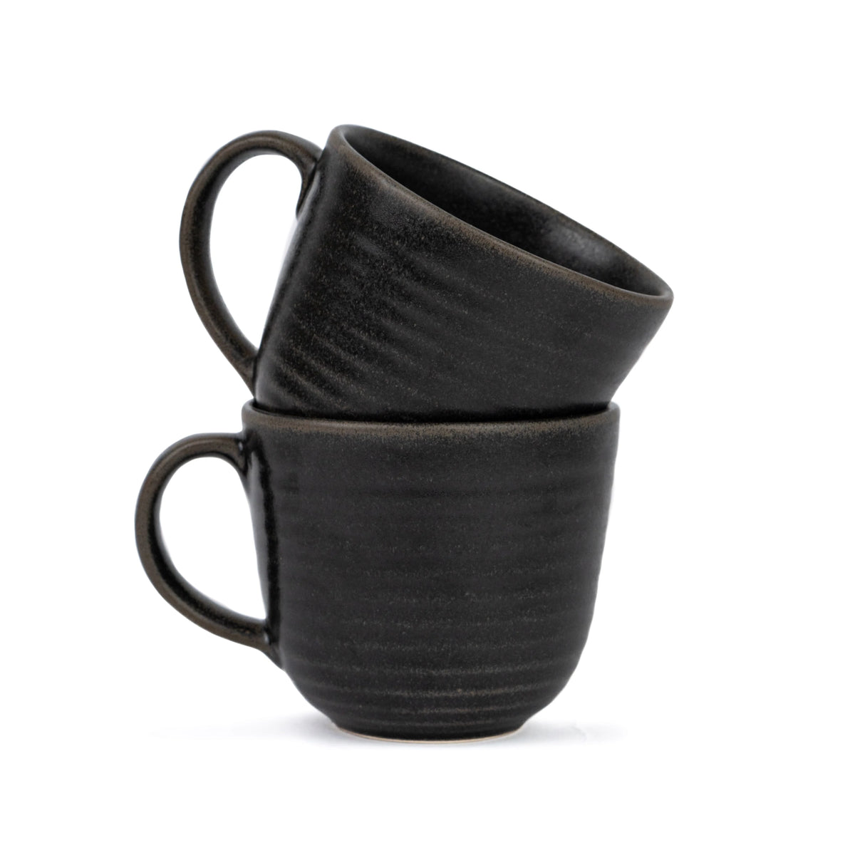 Two black ceramic mugs stacked on a white background