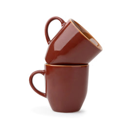 Two brown ceramic mugs stacked on a white background