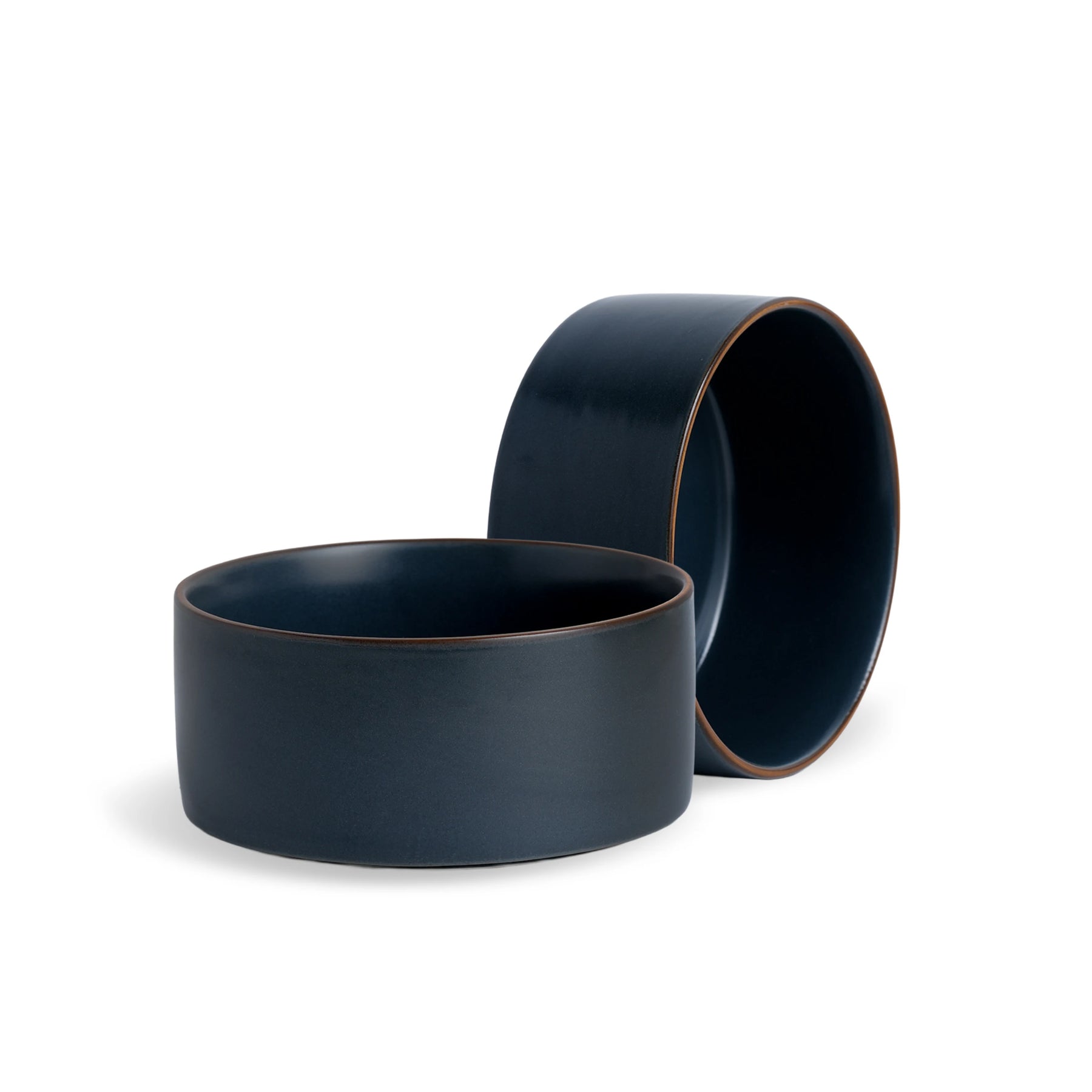 Two navy blue ceramic bowls on a white background