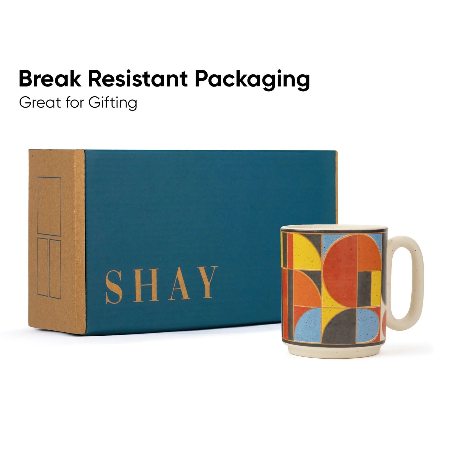 Colorful mug with geometric design next to a teal box labeled 'SHAY' on a white background.