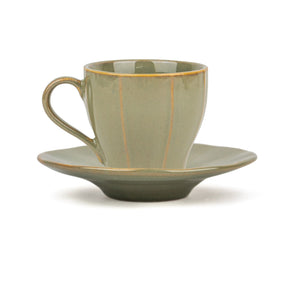 Green ceramic cup and saucer set on a white background