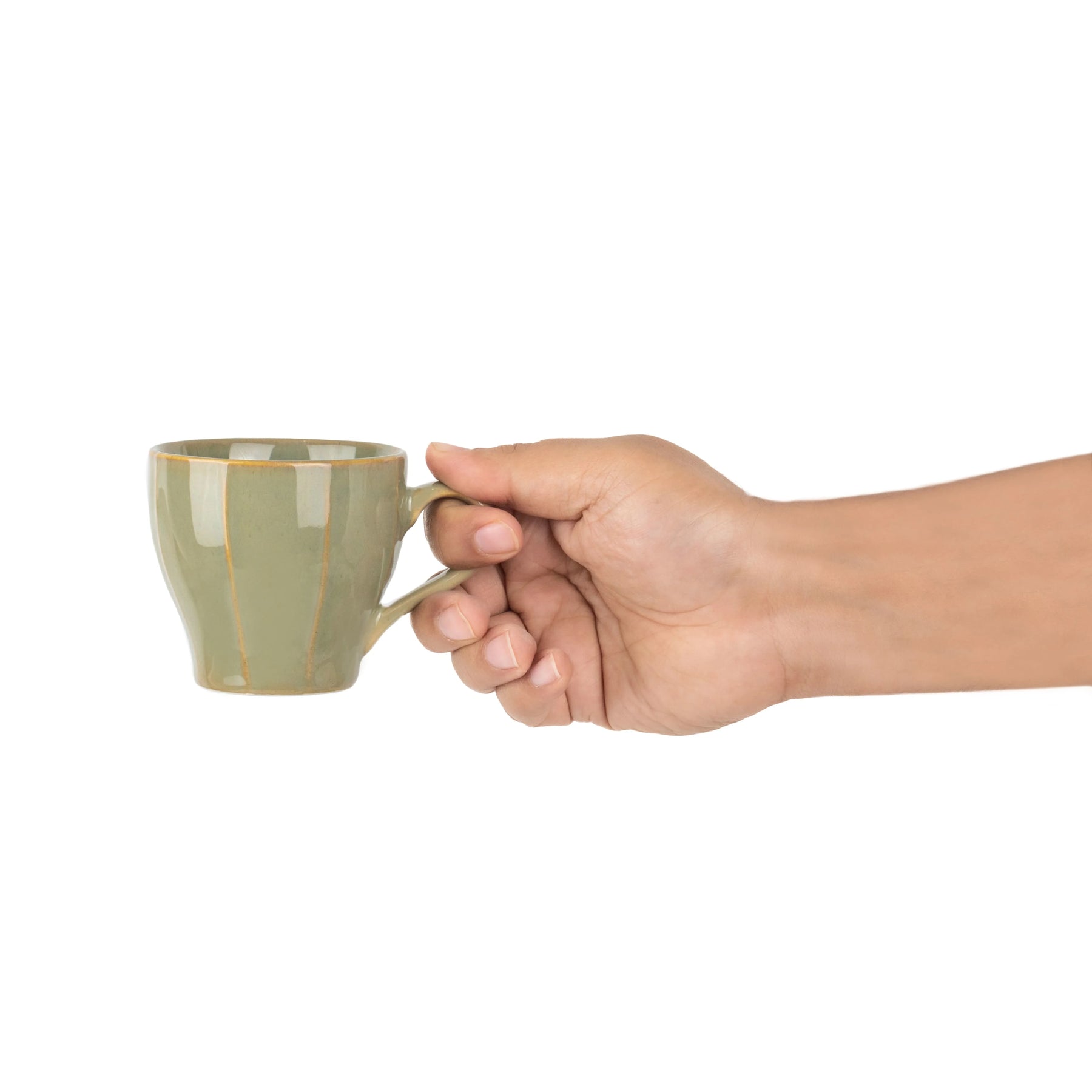 Hand holding a green ceramic mug on a white background