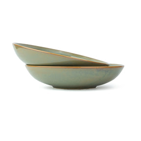 Two green ceramic bowls stacked on a white background